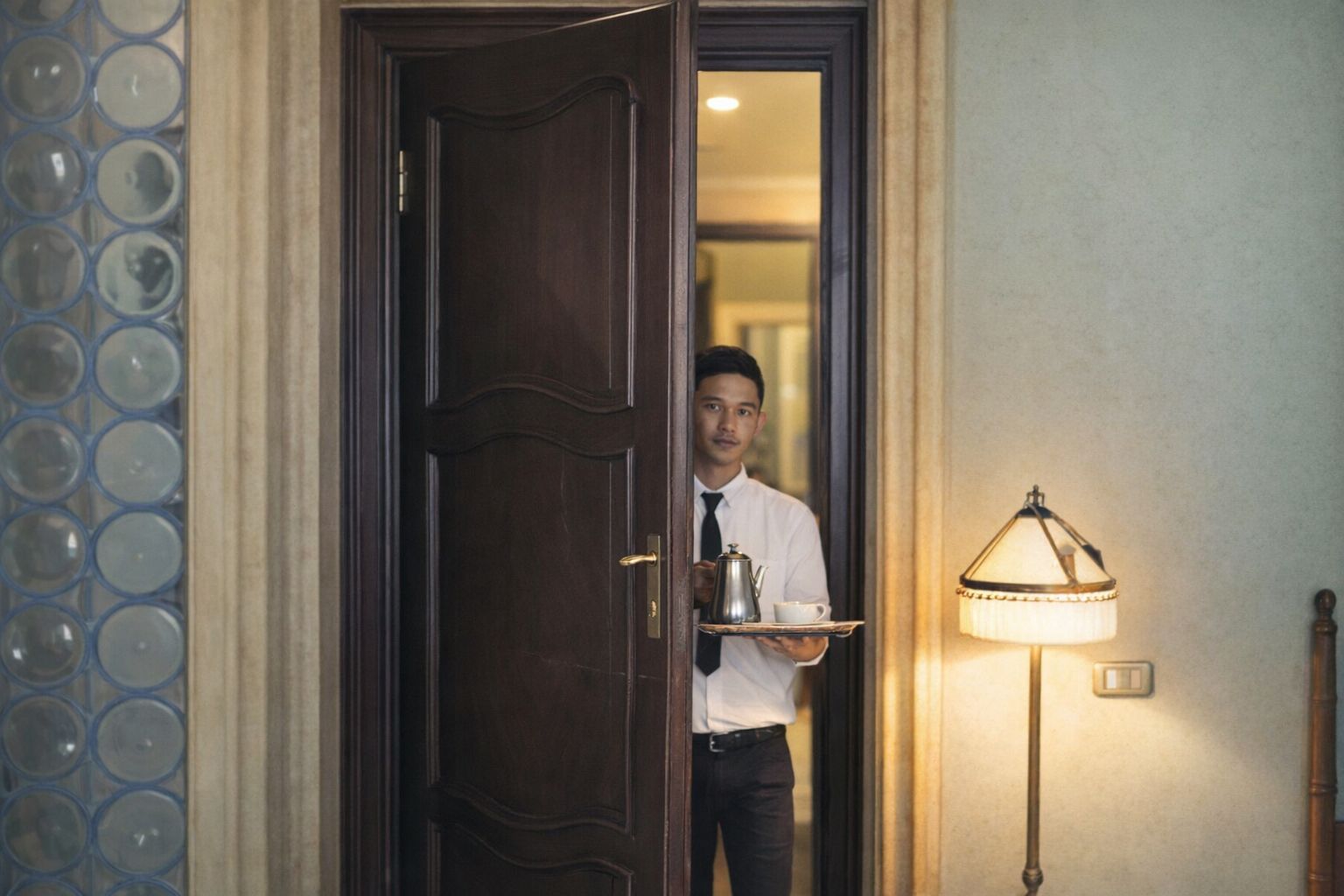 Hotellpersonal serverar frukost på sängen till ett par under en smekmånad.